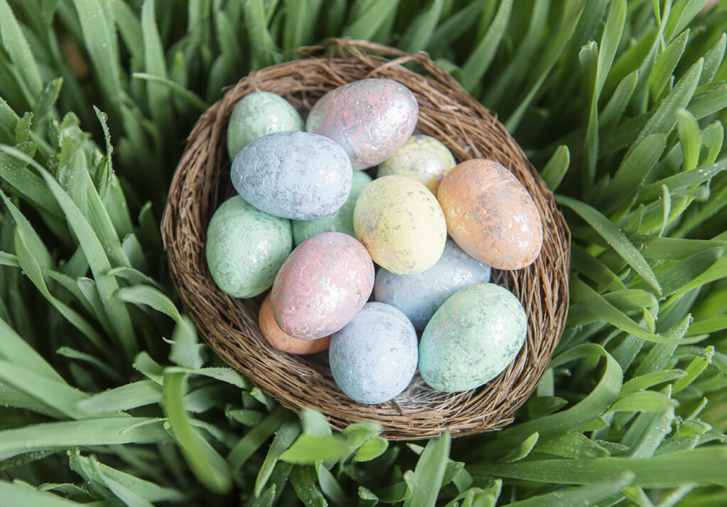 basket of colored eggs on grass